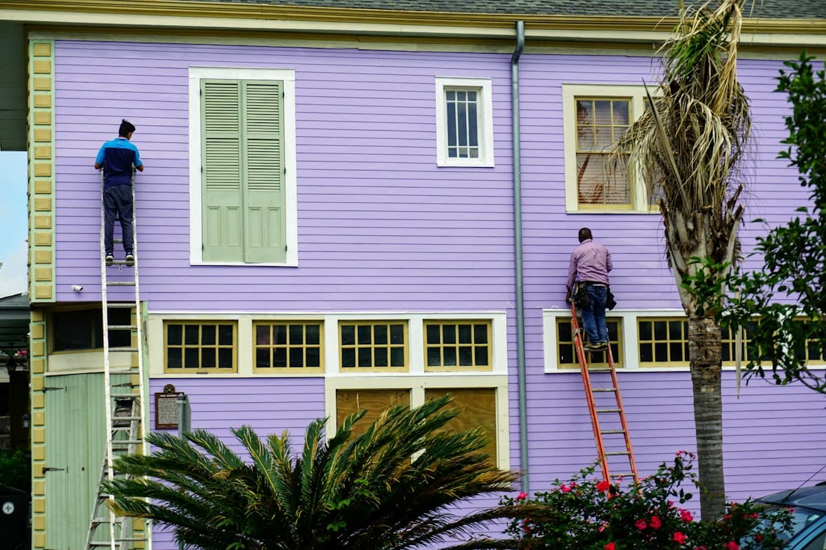 Painters actively painting the exterior of a house