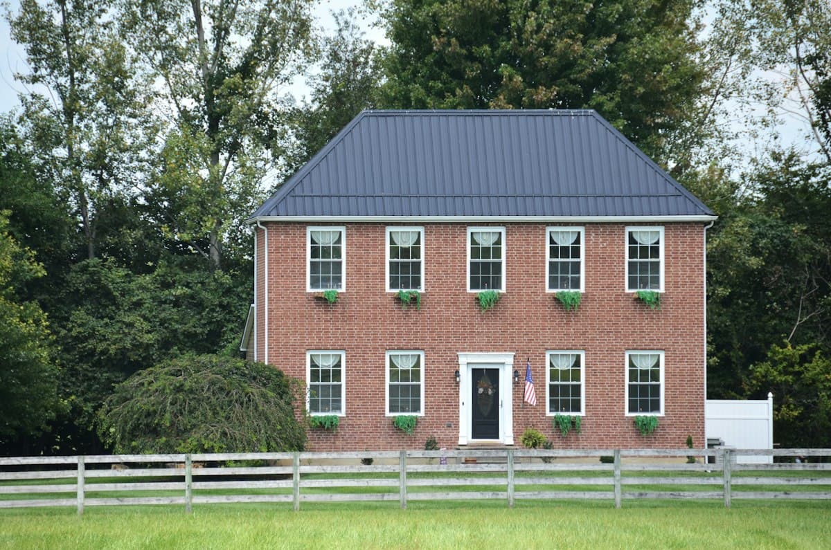 A brick colonial home with an American flag
